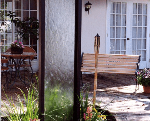 Freestanding garden waterfalls add a special feature to an entranceway, patio or even your living room, and can be buried into the ground to create the effect of a natural waterfall. Below is an elegant waterfall featuring clear glass with a beautifully finished weathered bronze frame. 